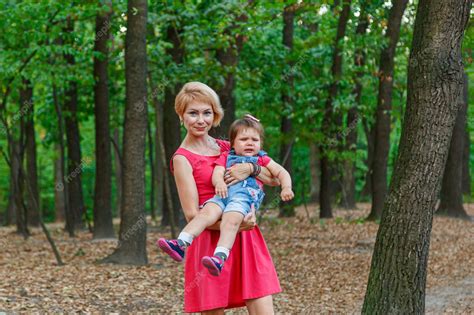Premium Photo Beautiful Mother With Her Daughter Walks In The Park In Summer