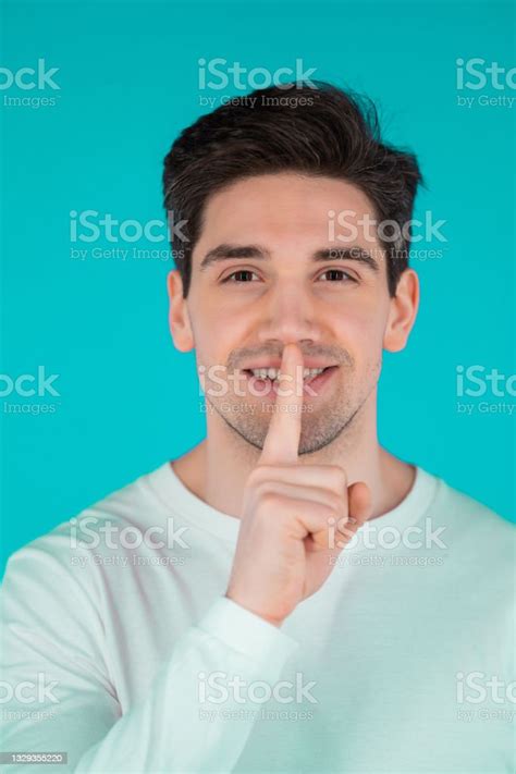 Smiling Man Holding Finger On Lips Over Blue Background Gesture Of Shhh