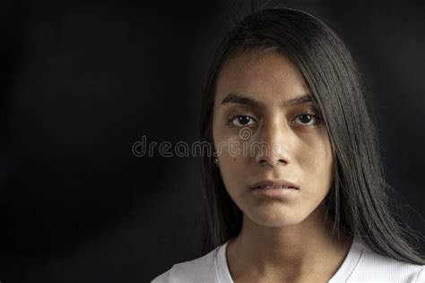 Close Up Of A Serious And Beautiful Black Haired Latina Woman Wearing A