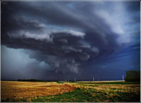 A Large Storm Moving Across The Sky Over A Field