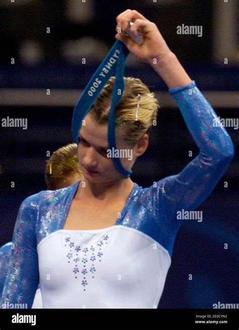 Russias Svetlana Khorkina Takes Off Her Silver Medal At The Finish Of