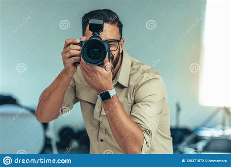 Portrait Of A Photographer Taking Photo Standing In A Studio Stock