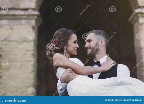 Groom Holds A Beautiful Bride In His Arms Stock Photo Image Of Groom