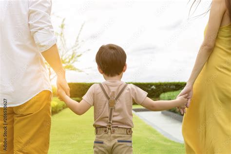 Foto De Cute Kid Or Handsome Son Walking With Parents Father And