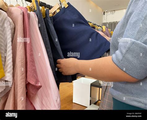 Closeup Photo Of Woman Hands Choosing Skirt At Clothing Store Stock