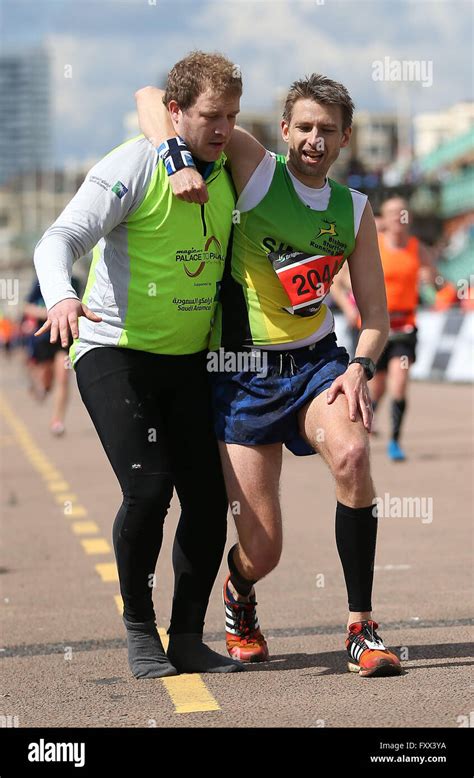 A Official Helps An Exhausted Runner Reach The Finish Line Of The 2016