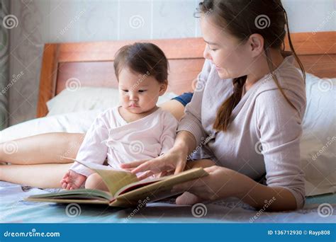 Mother Reading A Book To Her Child On The Bed Bedtime Story Learning