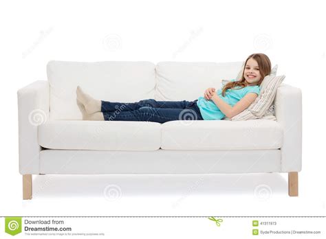 Toys on carpet and child lying on sofa behind. Smiling Little Girl Lying On Sofa Stock Photo - Image ...