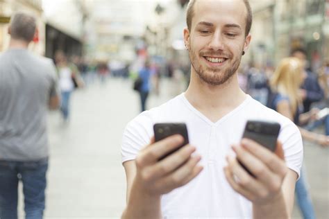 Man Holding Two Phones What Mobile Phone Is Beter Free Mobile