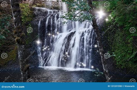 Waterfall With Dancing Fairy Lights In Enchanted Forest Stock Photo