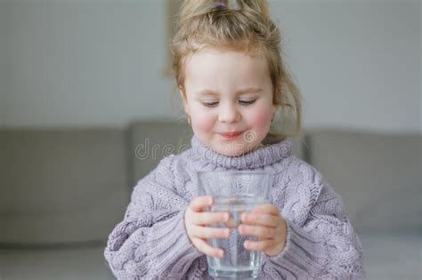 A Little Girl Holds A Glass Of Water Drinks Stock Image Image Of
