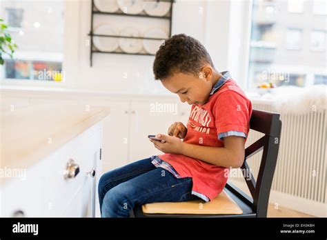 Boy Playing Games On Mobile Phone At Home Stock Photo Alamy