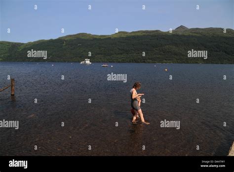 Woman And Child Paddling In Water Colling Down Loch Lomond Tarbet
