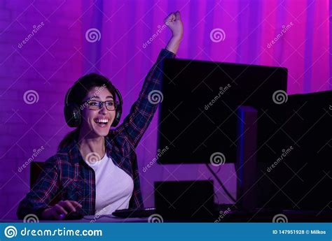 Gamer Girl In Headphones Rejoicing When Playing Video Games Stock Photo