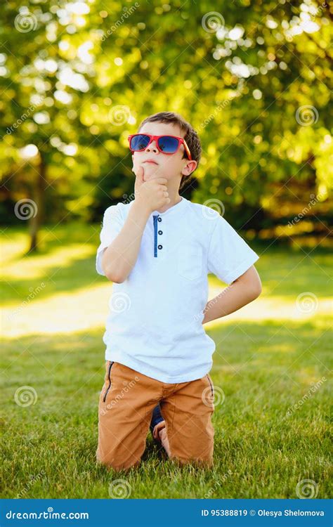 Portrait Of Pensive Little Boy Kneeling On Grass Stock Image Image Of