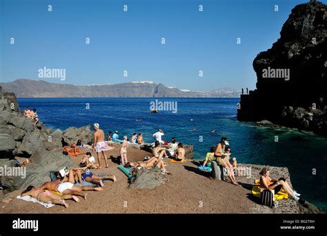 Tourists Swimming And Sunbathing At Ammoudi Bay Near Oia Village