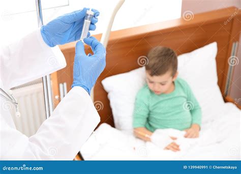 Doctor Adjusting Intravenous Drip For Child In Hospital During Parent`s