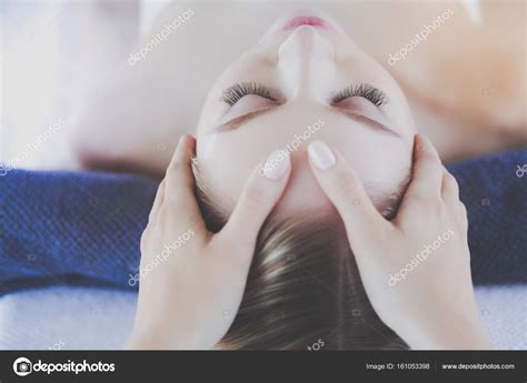 jovem deitada em uma mesa de massagem relaxando com os olhos fechados mulher salão de spa