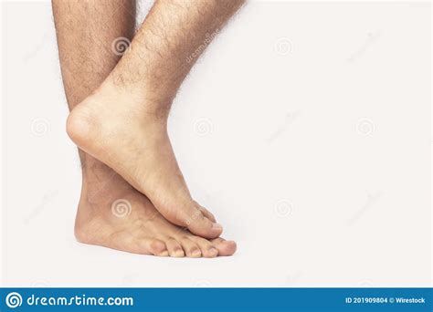 Closeup Of Male Feet Standing Lazily Against A White Background Stock