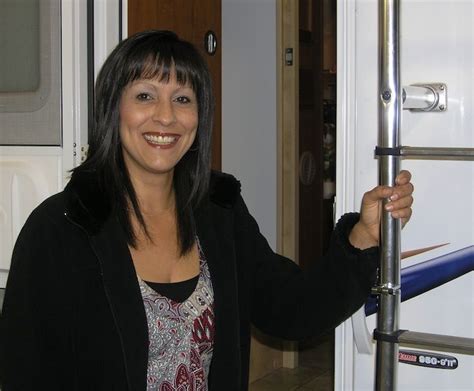 A Woman Is Smiling And Holding Onto The Handle Of A Door