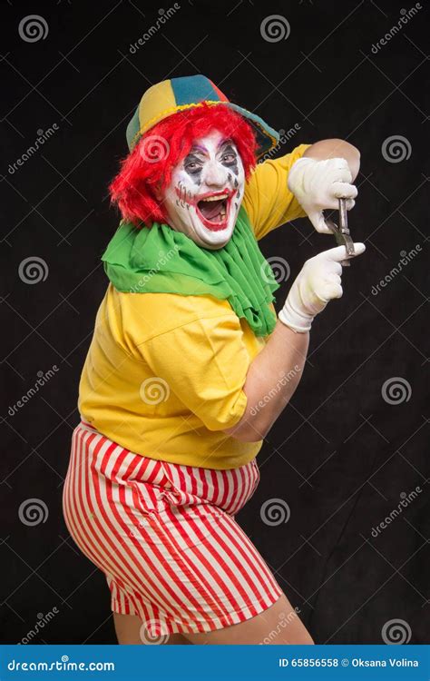 Scary Evil Clown With An Ugly Smile And A Pair Of Pliers On A Bl Stock