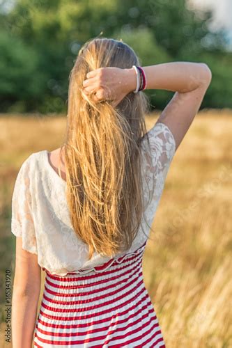 Ein Junges Mädchen Greift Von Hinten In Ihre Haare In Einem Weizenfeld Stockfotos Und
