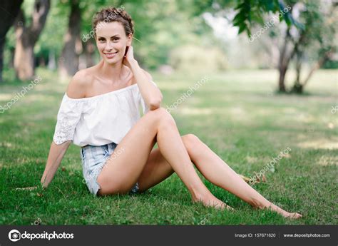 hermosa chica sexy en pantalones cortos descansando en un parque en la hierba fotografía de