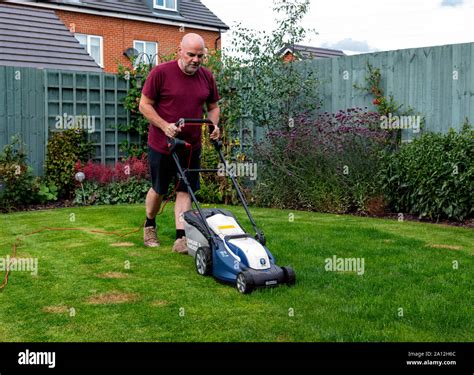 Man Mowing His Lawn With A Spear And Jackson Electric Lawnmower Facing