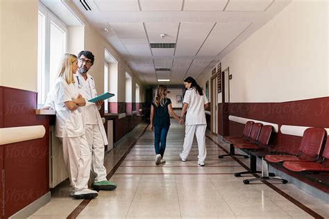 Conversation Between Doctor And Nurses In Hallway By Stocksy