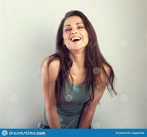 happy laughing beautiful woman covering the face the hands on blue background and happy looking