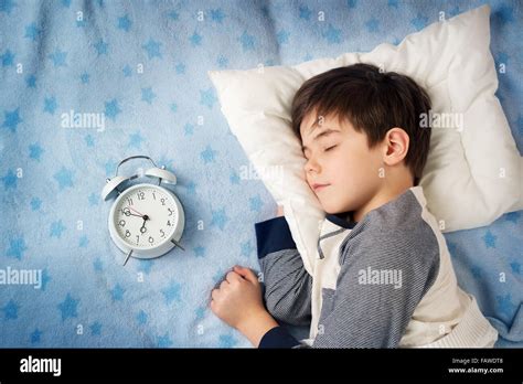 Six Years Old Child Sleeping In Bed With Alarm Clock Stock Photo Alamy