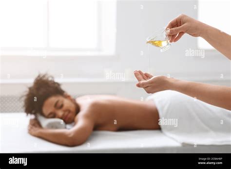 Massage Therapist Pouring Oil On Her Hands Before Procedure Stock Photo