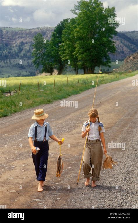 Returning From Fishing Trip Barefoot Children Walk Down A Rural Montana