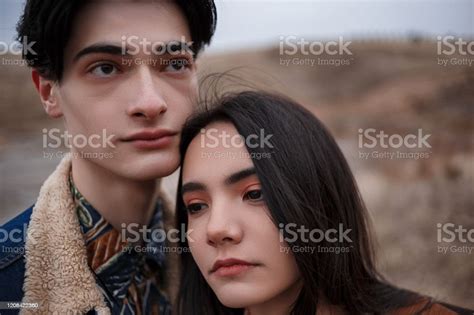 Dramatic Portrait Of A Young Brunette Girl And A Guy In Cloudy