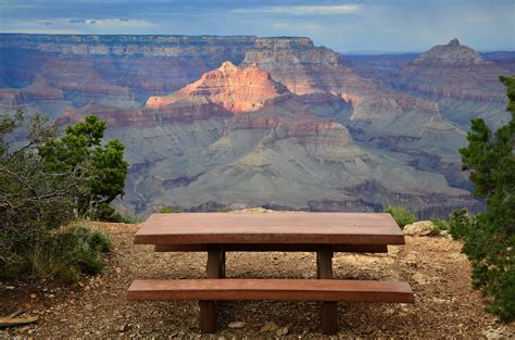 Brown Wooden Table On Top Of Grand Canyon During Day Time Grand Canyon