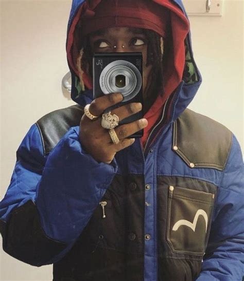 A Man Taking A Selfie In Front Of A Mirror Wearing A Blue And Black Jacket