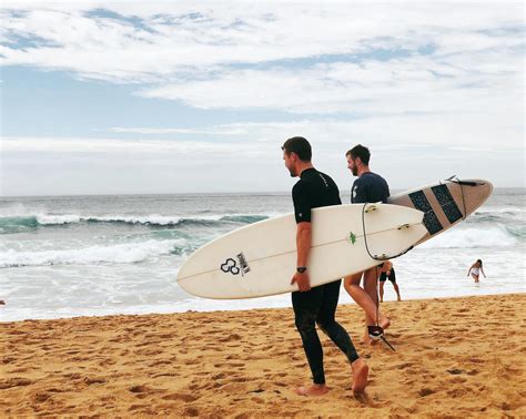 Two Men Carrying Surfboards Near Seashore · Free Stock Photo