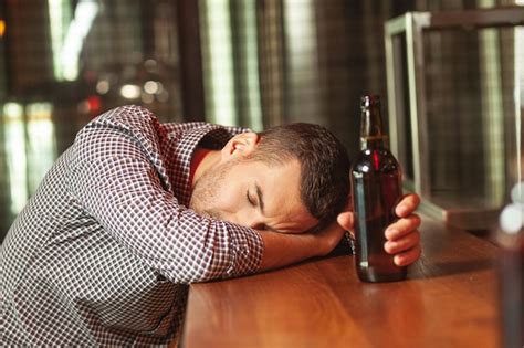 Premium Photo Drunk Man Sleeping On The Bar Counter Holding Glass On Beer