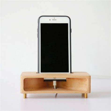 An Iphone Is Sitting On Top Of A Wooden Docking Station That Holds A