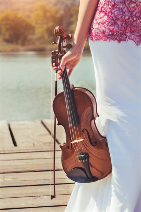 Female Hands Holding Music Instrument Violin Next To The Lake Yeager