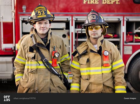 Two Firefighters Standing In Front Of A Fire Engine Stock Photo Offset
