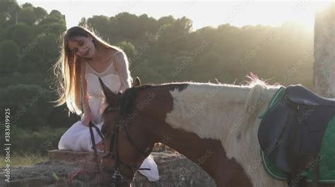Woman Gently Touhing And Caressing A Horse In The Forest At Sunset