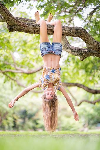 Beautiful Woman Hanging Upside Down From A Huge Tree Branch Enjoying