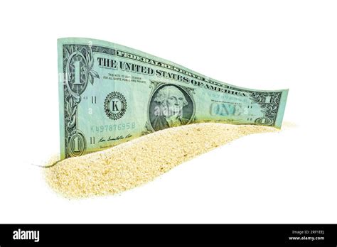 Single one-dollar bill rests amidst a pile of fine sand on a clean
