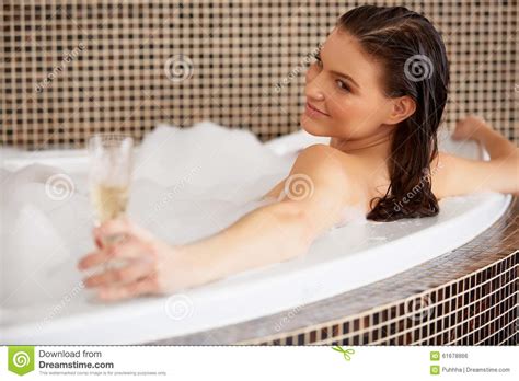 Woman Relaxing In Bubble Bath With Rose Petals Body Care Stock Photo