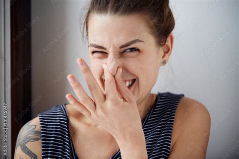 Female Gesture Smells Bad Headshot Woman Pinches Nose With Fingers