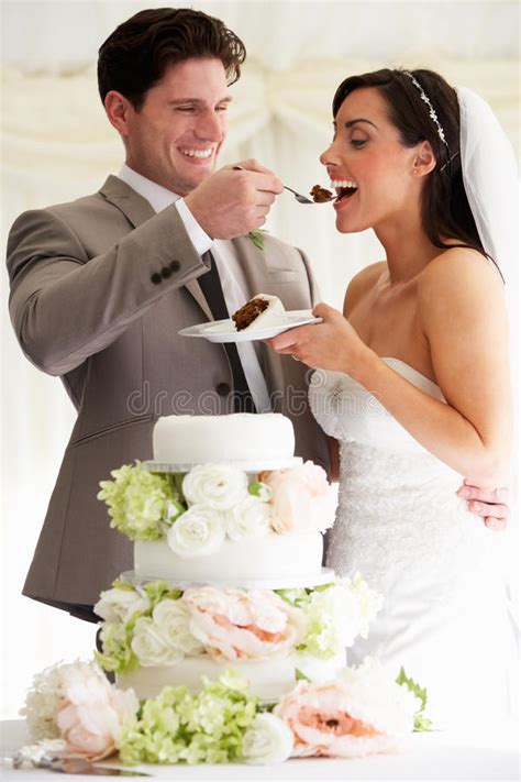 groom feeding bride with wedding cake at reception stock image image of beautiful twenties
