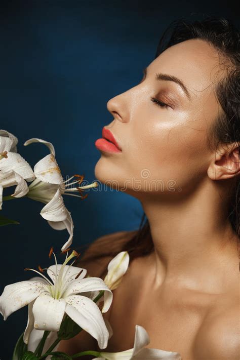 Naked Slim Woman Posing With Eyes Closed Holding Lily Flowers Stock