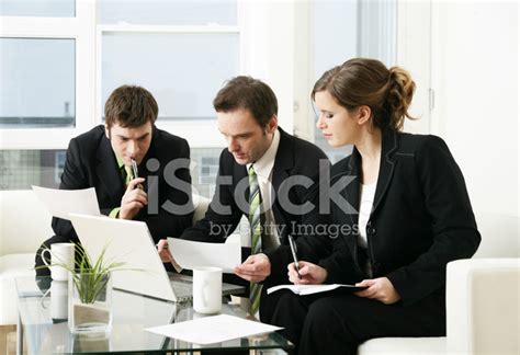 Three Business People In Suits Gathered At Laptop Stock Photo Royalty