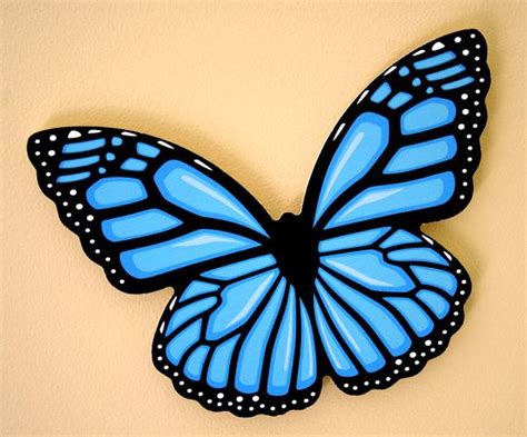 A Blue Butterfly Sitting On Top Of A Wall
